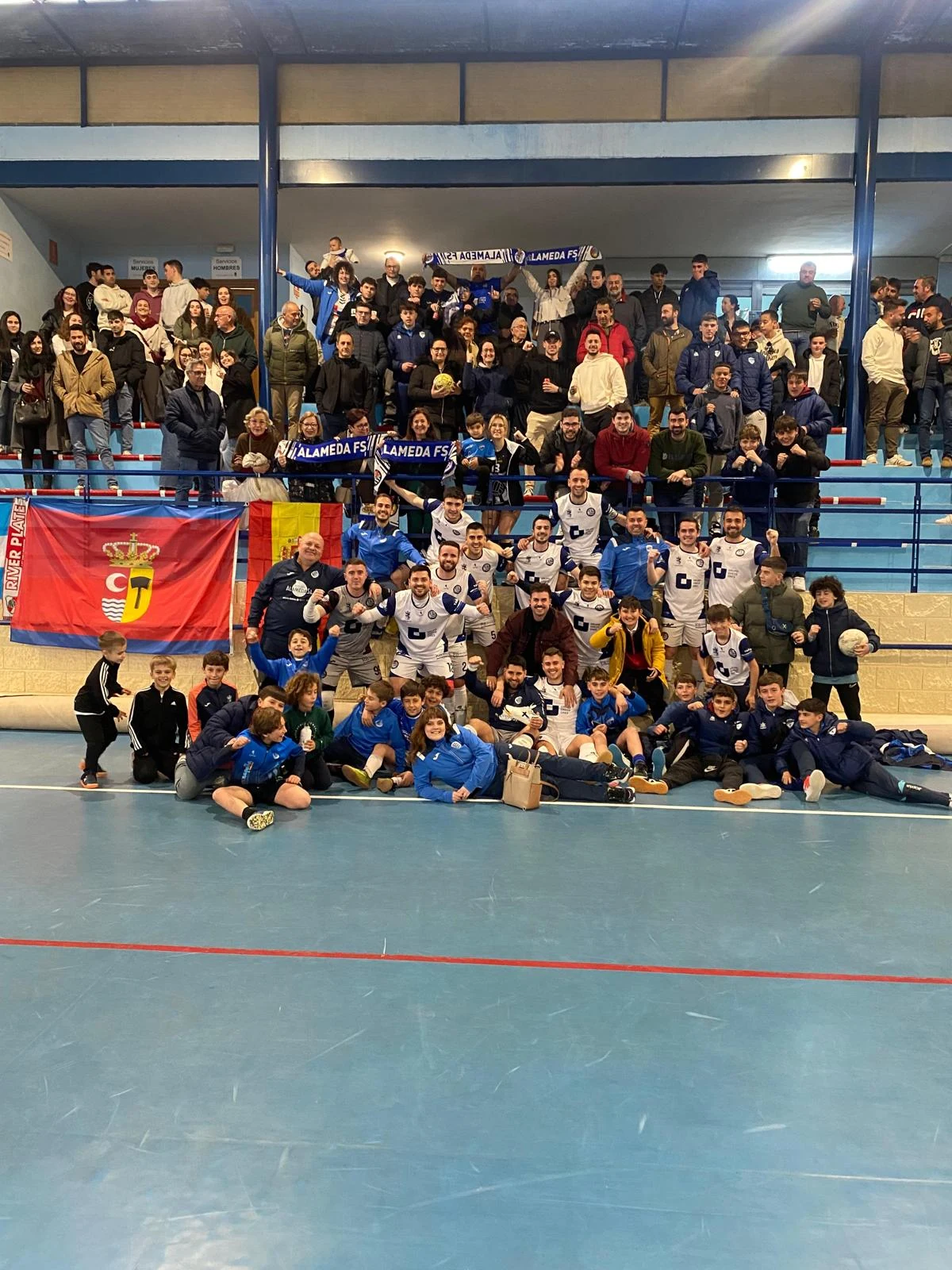 La afición y el equipo de Alameda FS juntos en el pabellón, con las bufandas del club