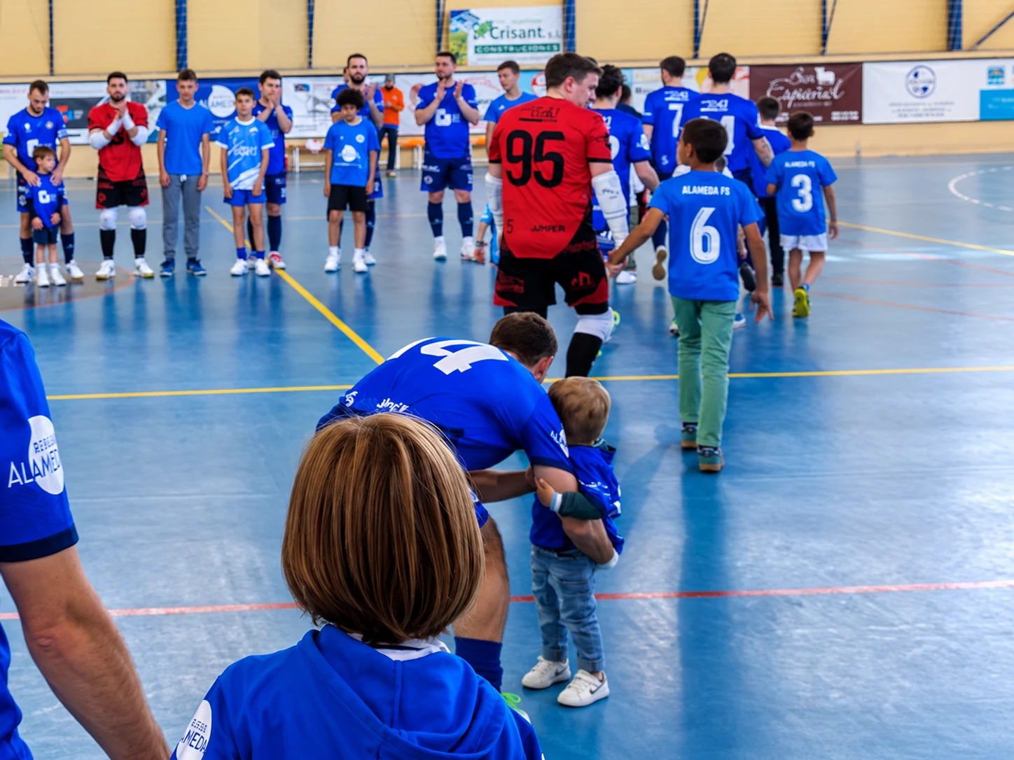 Niños de Alameda compartiendo la pista con los jugadores del club antes de un partido